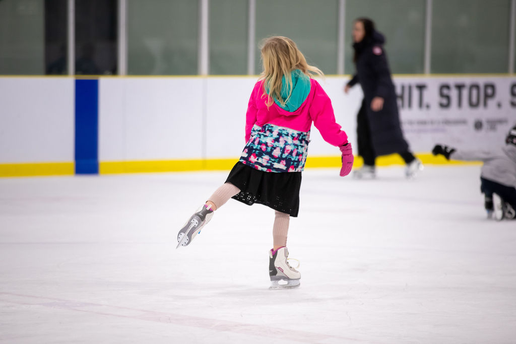 Girl ice skates on arena ice pad