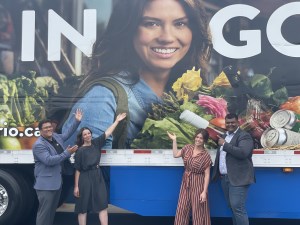 Mayor Dennis Rogers, Economic Development and Tourism Officer Sue Rice, Model Jessica Muzzin and SK Cornerstone Owner Yudi Persaud pose in in front of truck trailer with Kingsville's new tourism asset